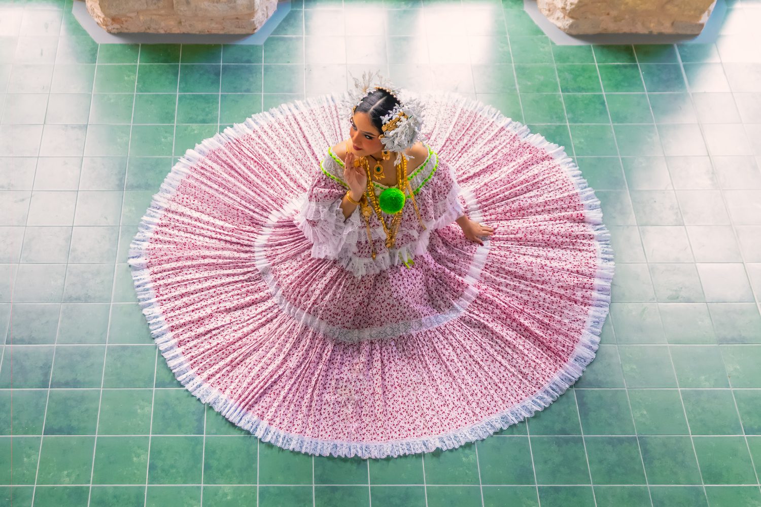 Pollera panameña extendida sobre un patio de porcelanato verde.